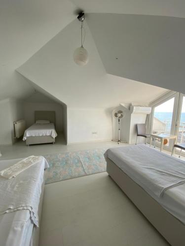 a white bedroom with a bed and a window at sunset villa in Cimenli