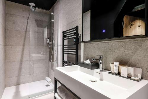 y baño con lavabo blanco y ducha. en Leprince Hotel Spa; Best Western Premier Collection en Le Mans