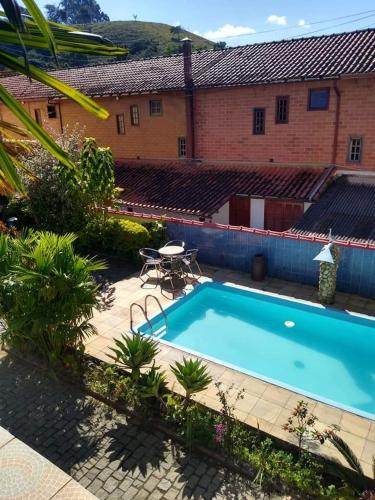 a swimming pool in front of a building at Pousada Oca Porã in Conservatória