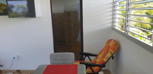 a chair sitting in a room with a window at Soleil levant in Petit-Bourg