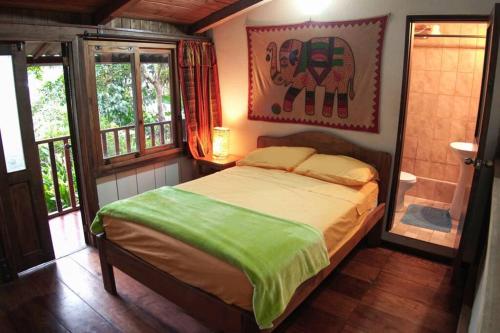 a bedroom with a bed and an elephant picture on the wall at Mindo cozy house in Mindo