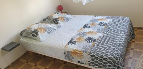 um quarto com uma cama com um edredão azul e branco em Soleil levant em Petit-Bourg