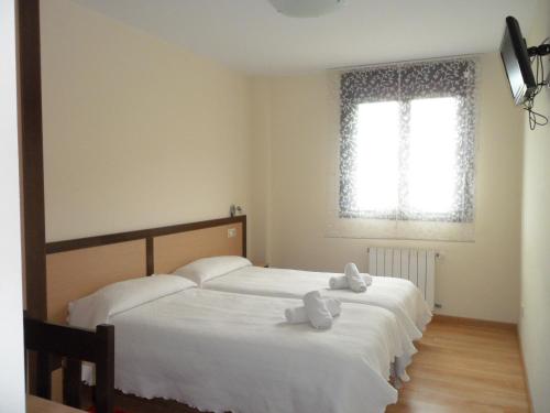 a bedroom with two beds with white towels on them at Pensión la Posada in Tineo