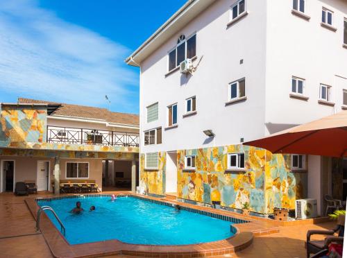 a swimming pool in front of a building at Midindi Hotel in Accra