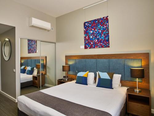a hotel room with a bed, chair, and nightstand at Quest Albury on Townsend in Albury