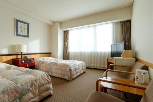 a hotel room with two beds and a television at Toya Kohan Tei in Lake Toya