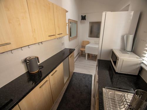 a kitchen with a white refrigerator and a microwave at North Bay Holiday Apartment with Internet, Smart TV's and Patio Area in Scarborough
