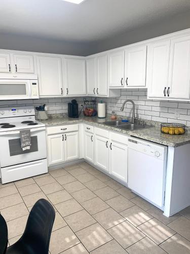a kitchen with white cabinets and a sink and a stove at Superb For Traveling Workers Near Cartersville MC in Cartersville