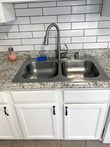 a stainless steel sink in a kitchen with white cabinets at Superb For Traveling Workers Near Cartersville MC in Cartersville