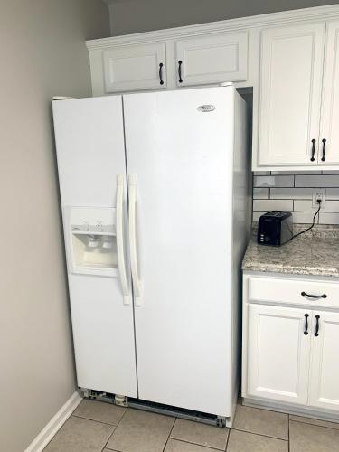 a white refrigerator in a kitchen with white cabinets at Superb For Traveling Workers Near Cartersville MC in Cartersville