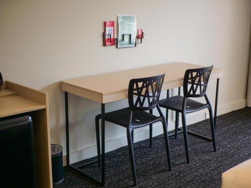 a table and two chairs in a room at Nightcap at Hinterland Hotel Nerang in Gold Coast