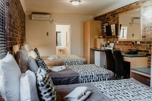 a hotel room with two beds and a kitchen at Inverell Terrace Motor Lodge in Inverell