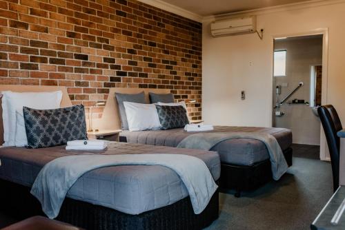 A bed or beds in a room at Inverell Terrace Motor Lodge