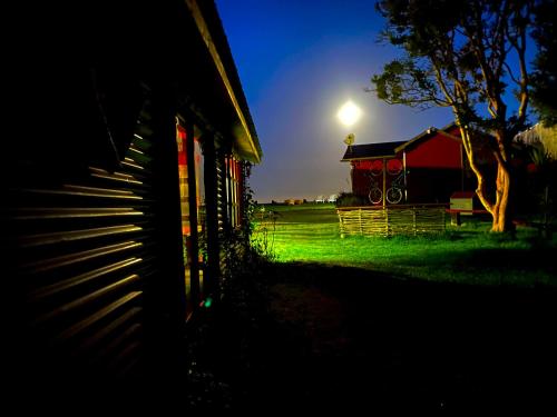 a barn at night with the moon in the sky at El Reflejo Lodge Spa - Queilen - Chiloé in Queilén