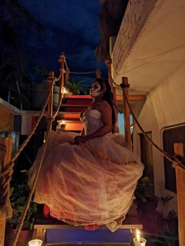 a woman in a dress sitting on a staircase at La Máxima & LGBT in Zipolite