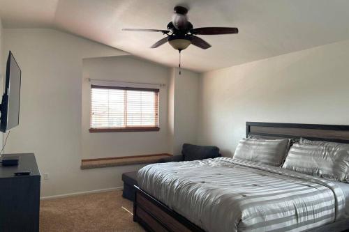 a bedroom with a bed and a ceiling fan at 2 Master Suites/3 King Beds/4 Bath/Mins to Airport in Colorado Springs