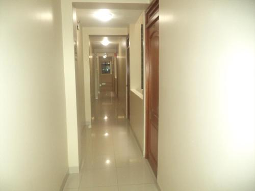 a hallway with white walls and a long corridor at Hotel Primavera in Chiclayo