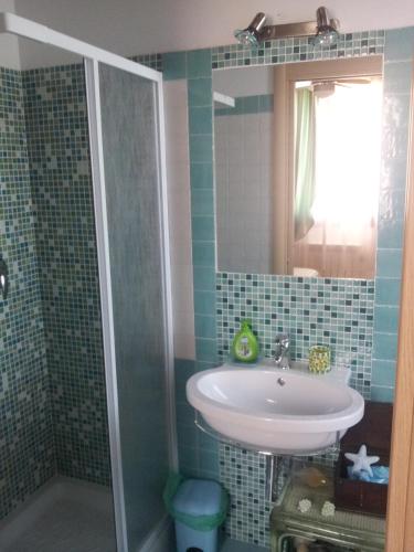 a bathroom with a sink and a mirror and a shower at Agriturismo La Nocciolina in Venturina Terme