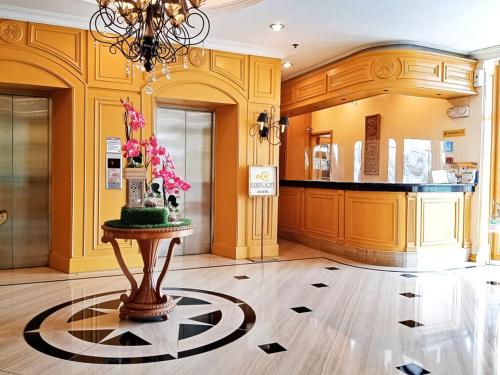 una grande stanza con un tavolo con fiori sul pavimento di The Grand Dame Hotel a Città di Iloilo
