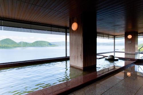 a room with a view of a body of water at Toya Kohan Tei in Lake Toya
