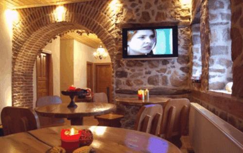 a restaurant with tables and a television on a wall at Nimbus Guesthouse in Kastoria