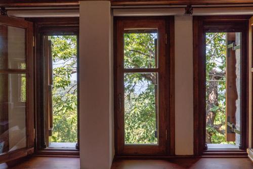 three windows in a room with trees at Helene Eco Luxury Villa in Tsagarada