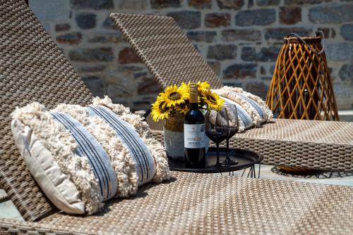 a bottle of wine sitting on a table with pillows at Helene Eco Luxury Villa in Tsagarada