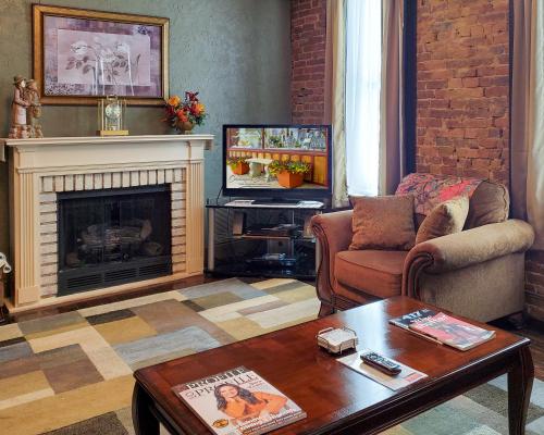 a living room with a fireplace and a television at Guest Apartment at Commercial Street Studio in Lebanon