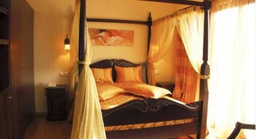 a bedroom with a canopy bed with pillows at Ateron Suites Hotel & Spa in Amyntaio