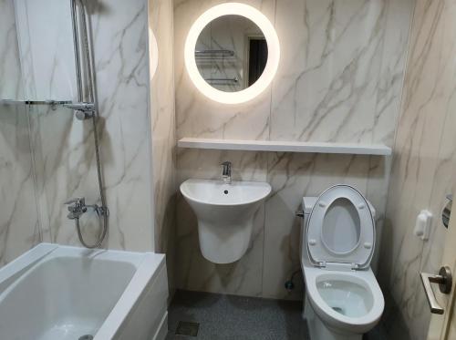 a bathroom with a toilet and a sink and a mirror at Prime Tourist Hotel in Busan