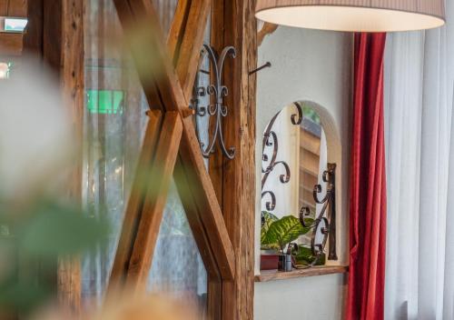 a room with a mirror and a lamp and a red curtain at Garden Wellness Hotel S in Andalo