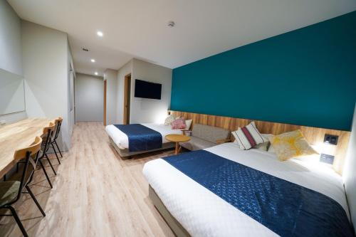 um quarto de hotel com duas camas e uma televisão de ecrã plano em Hotel S-Presso East em Osaka