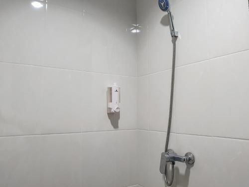 a shower in a white bathroom with a shower at RedDoorz near Istana Plaza 3 in Bandung
