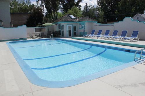 a large swimming pool with chairs around it at Tiki Shores Inn & Suites in Penticton