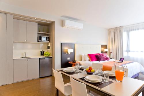 a room with a bed and a table with a kitchen at Bulnes Eco Suites in Buenos Aires