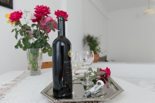 a bottle of wine on a table with glasses and flowers at Elpiniki in Alinda