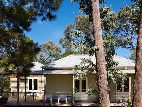 a white house with trees in front of it at Ashling in Hepburn Springs