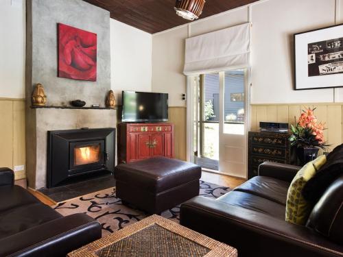 a living room with a couch and a fireplace at Ashling in Hepburn Springs