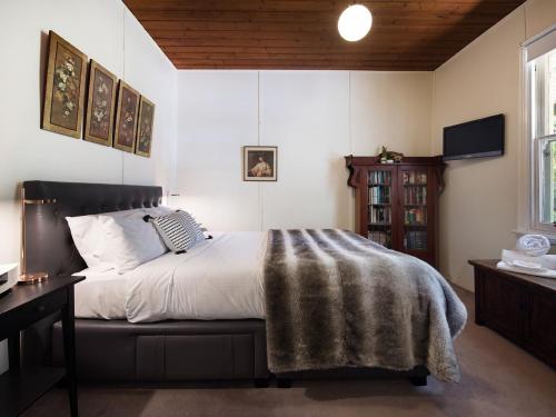 a bedroom with a bed with a blanket on it at Ashling in Hepburn Springs