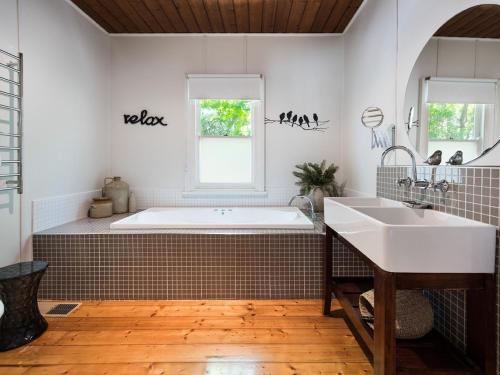 a bathroom with a tub and a sink at Ashling in Hepburn Springs