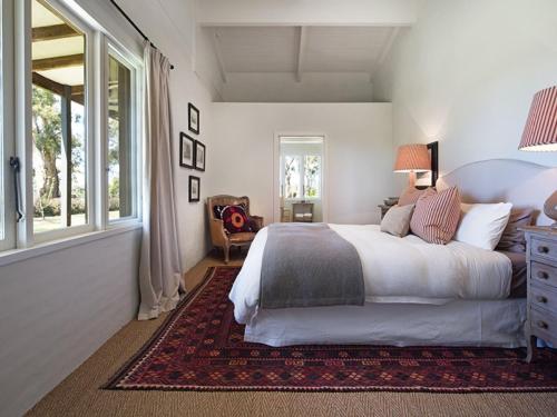 a bedroom with a large bed and a window at Paul Bangay The Farmhouse in Denver