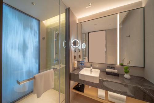 a bathroom with a sink and a mirror at Holiday Inn Qinhuangdao Haigang in Qinhuangdao