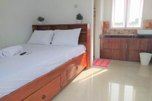 a bedroom with a large bed with a wooden frame at Guesthouse Berlian Batang Syariah near Kampung Kalisalak Park in Pekalongan
