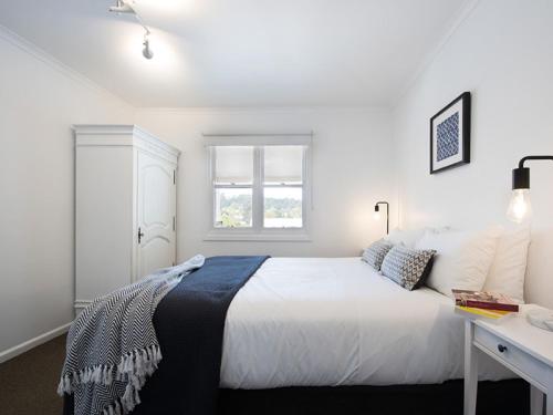 a white bedroom with a bed and a desk at Lake Daylesford Apartment 6 in Daylesford