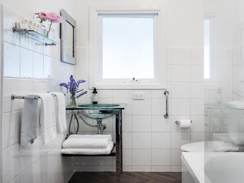 a white bathroom with a sink and a glass table at Lake Daylesford Apartment 6 in Daylesford