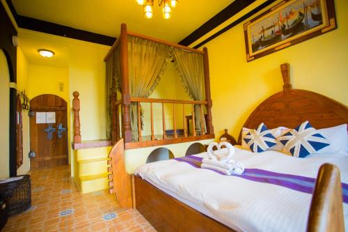 a bedroom with a large bed with a wooden headboard at 墾丁戀戀莎堡特色民宿 Castillo in Eluan