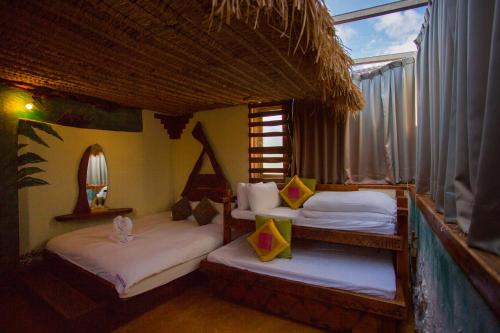 a room with three beds in a room with a window at 墾丁戀戀莎堡特色民宿 Castillo in Eluan