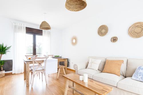 un soggiorno con divano bianco e tavolo di Apartamento Las Ocas "Solo Adultos" a Muros de Nalón
