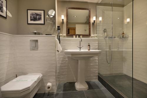 a bathroom with a toilet, sink, and mirror at LOFT Hotel Bratislava in Bratislava