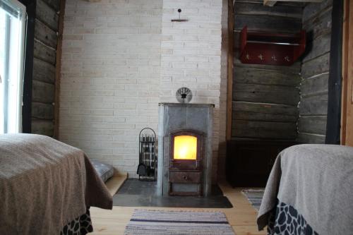 a fireplace in a room with a brick wall at Kainuun Luontoretket in Hossa